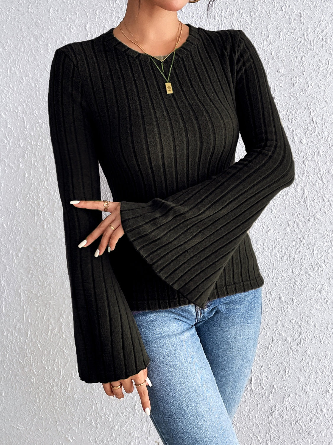 Black ribbed sweater with flared sleeves and crew neck.