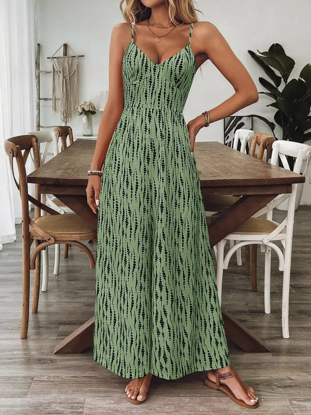 Matcha green wide-leg jumpsuit with black vertical dash print, V-neck, spaghetti straps.