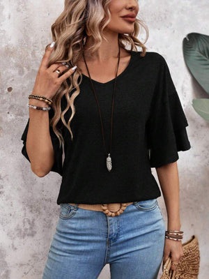 Black jersey tee with tiered short sleeves and v-neck, styled with jeans and necklace.