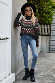 Geometric knit turtleneck sweater in black with red and grey pattern.