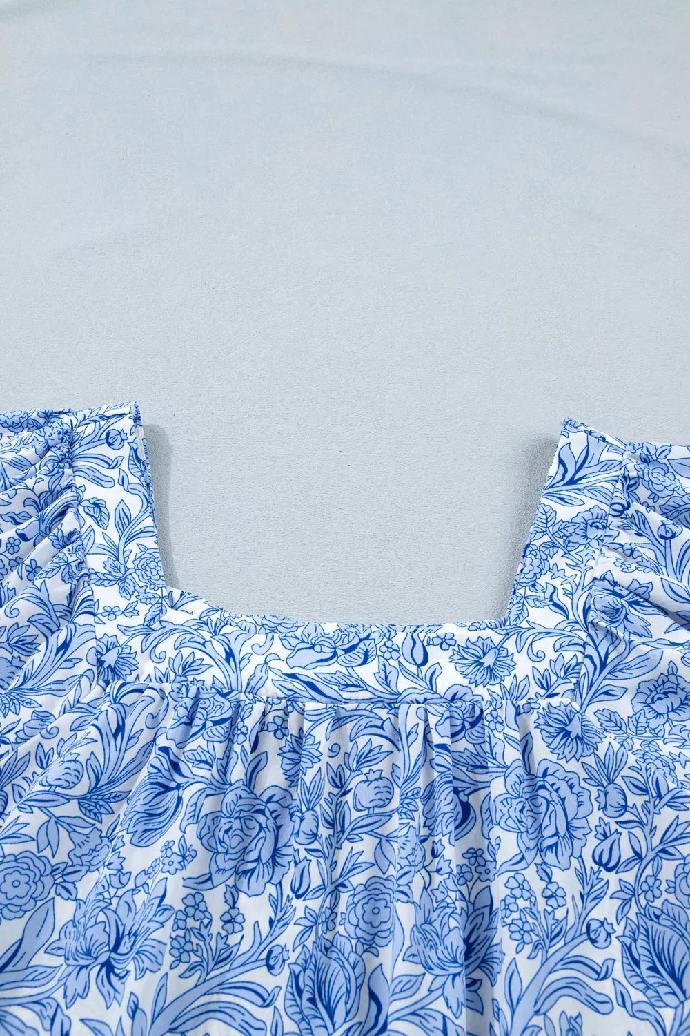 Floral pleated blouse with square neckline in blue and white polyester