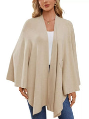 Beige knit cape top with draped elegance and tie front detail.