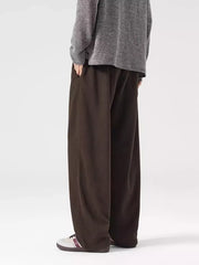 Brown loose-fit men's casual sweatpants with side pockets, styled with a grey sweater.