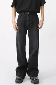 Dark wide-leg denim trousers with vertical seams and a relaxed fit.