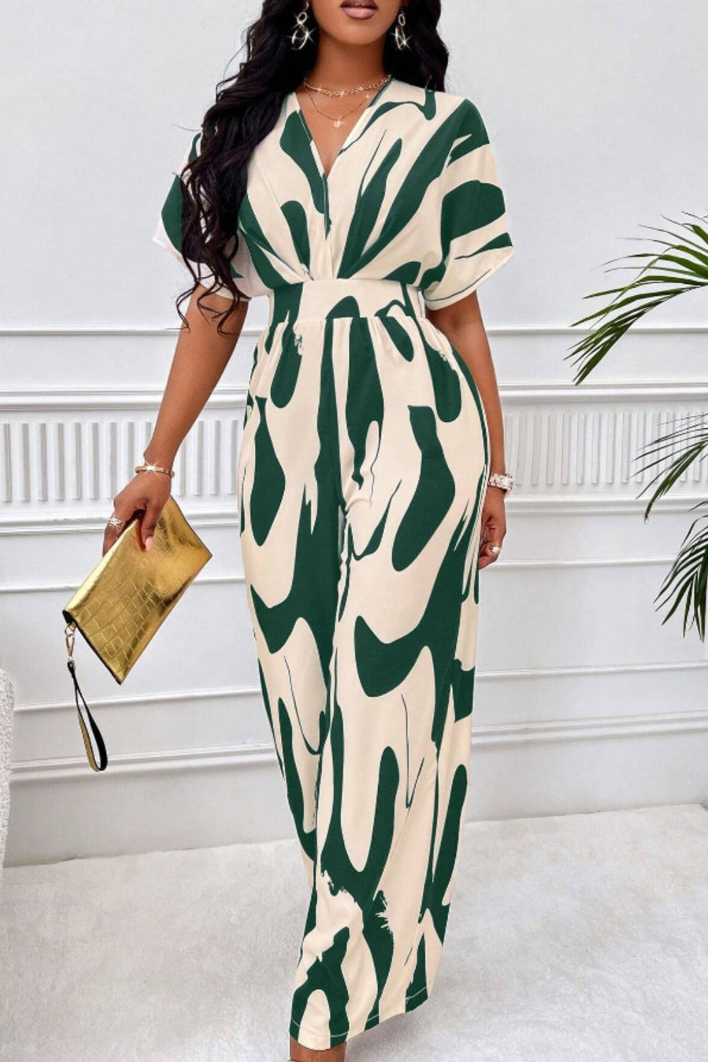 Abstract brushstroke wide-leg jumpsuit in cream and dark green with short sleeves and a V-neck.