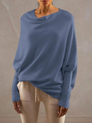 Dusty blue off-shoulder knit sweater with textured cuffs and draped neckline.