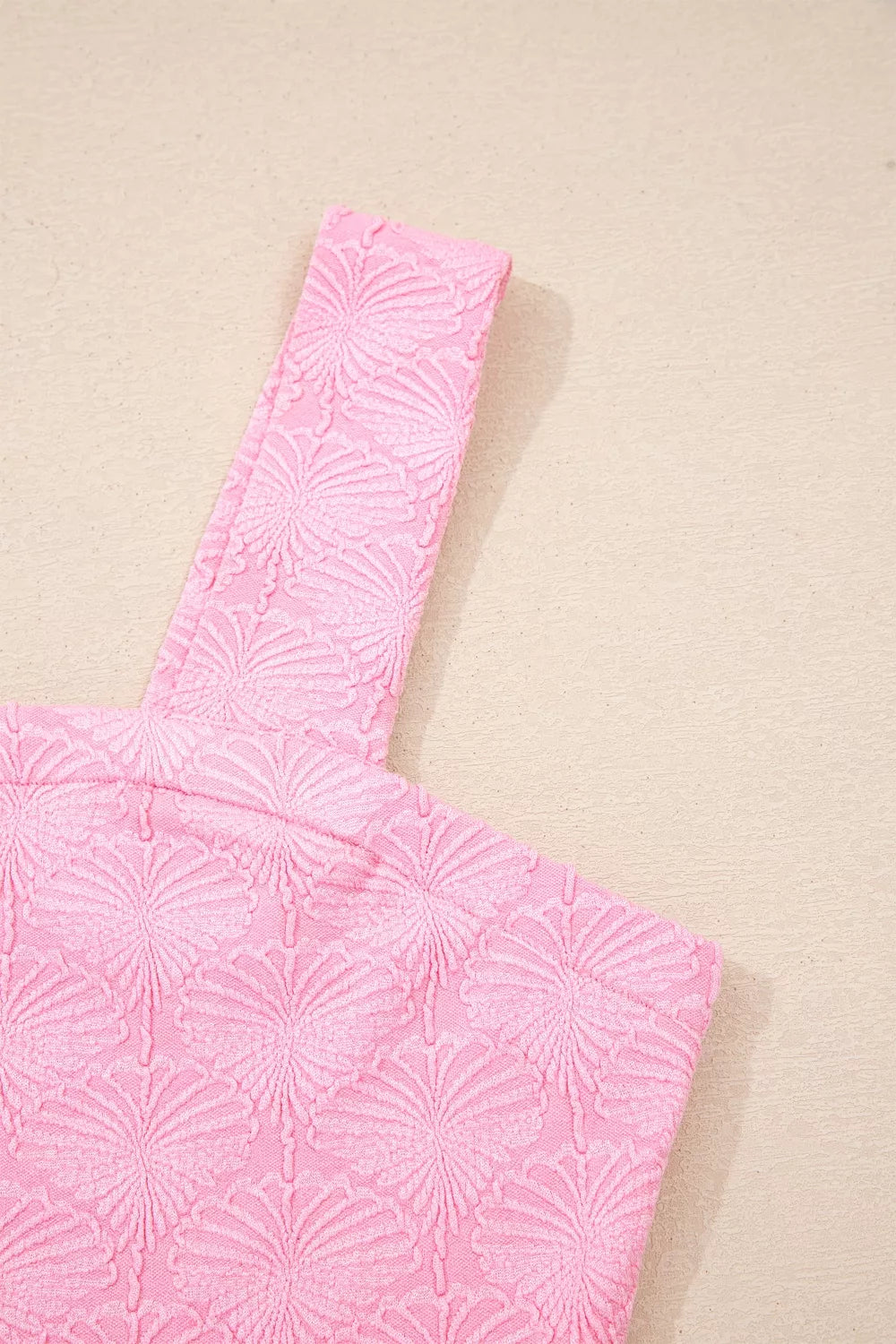 Pink textured square neck tank top with floral pattern and wide straps.