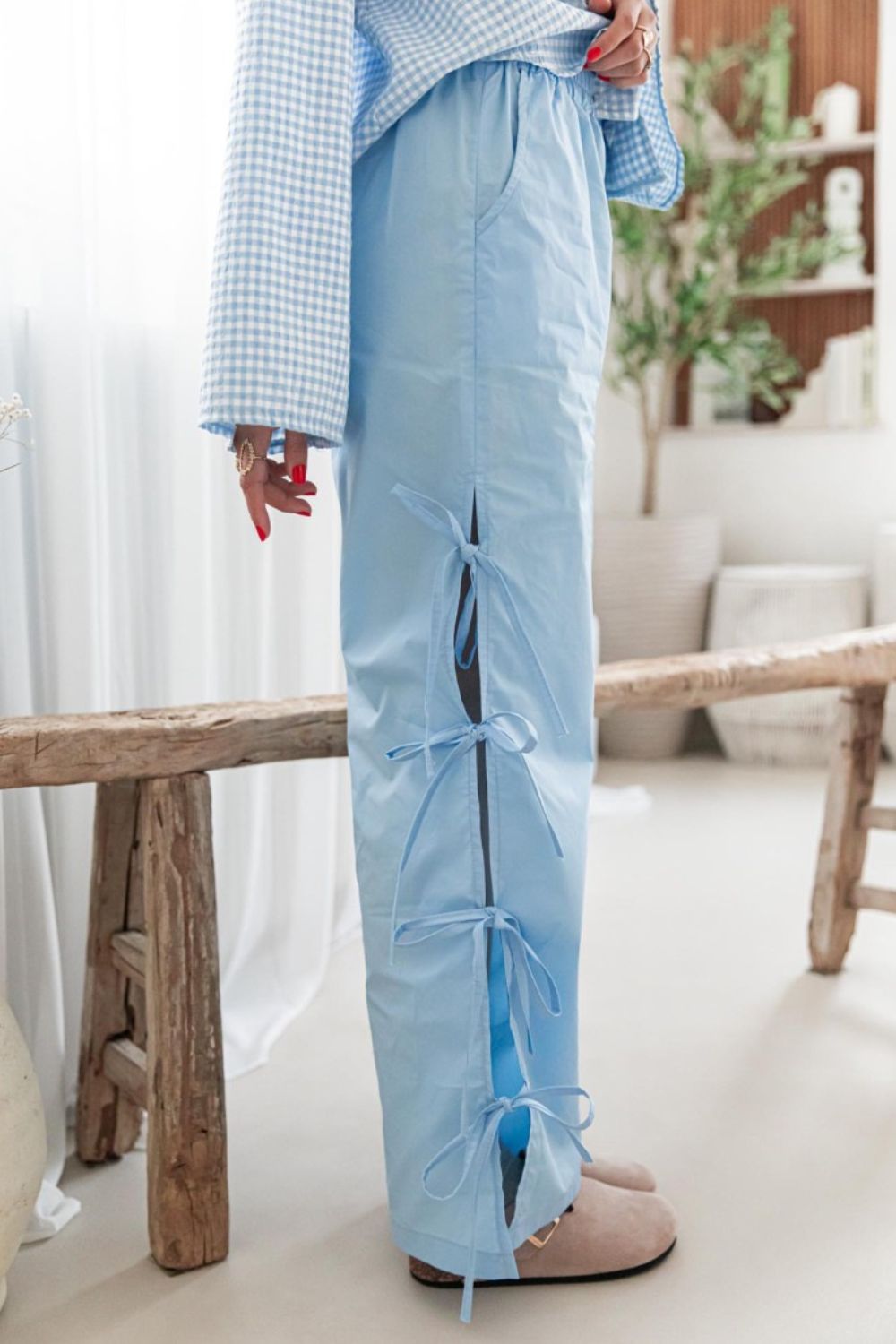 Light blue palazzo trousers with side tie details and pockets.