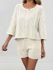Cream cable-knit two-piece sweater set with crew neck and drawstring shorts.