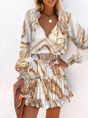 Abstract speckled tiered mini dress with ruffles and tie-neck in a marble-like print.