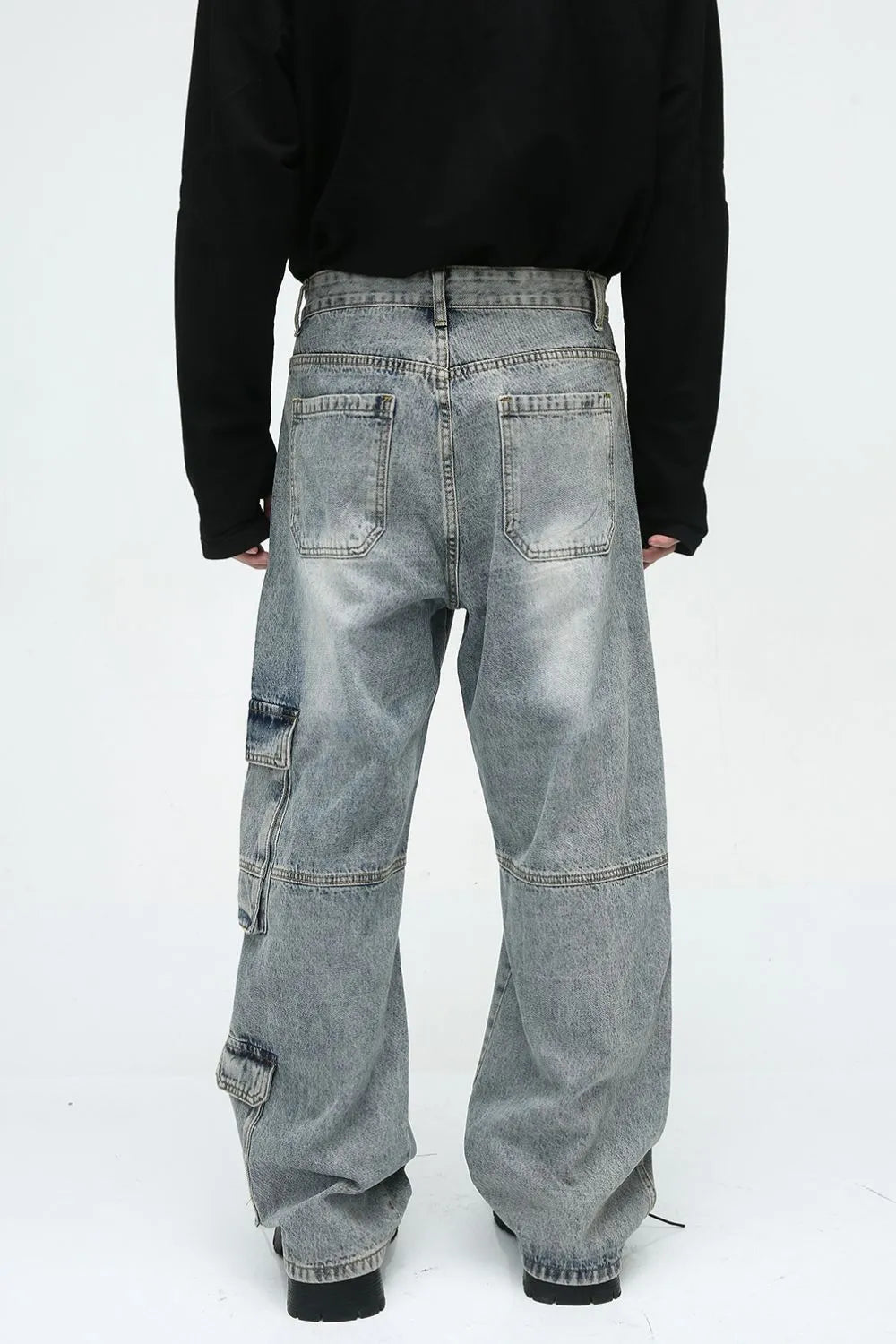 Medium wash wide leg cargo jeans with utility pockets and a relaxed fit.