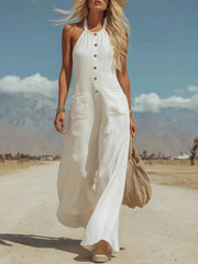 White halter neck jumpsuit with button front, pockets, and wide legs.