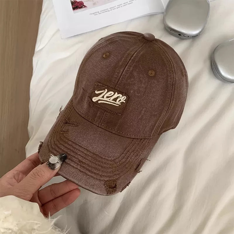 Brown distressed cotton baseball cap with "Zero" patch and frayed details