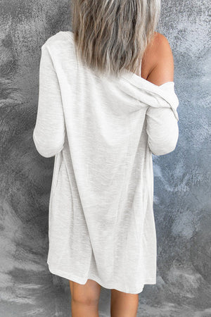 White button-down maxi cardigan with long sleeves and an open front, styled casually.