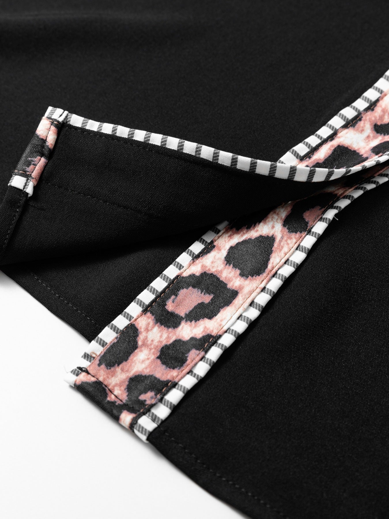 Black blouse with leopard print trim and striped piping detail.