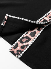 Black blouse with leopard print trim and striped piping detail.
