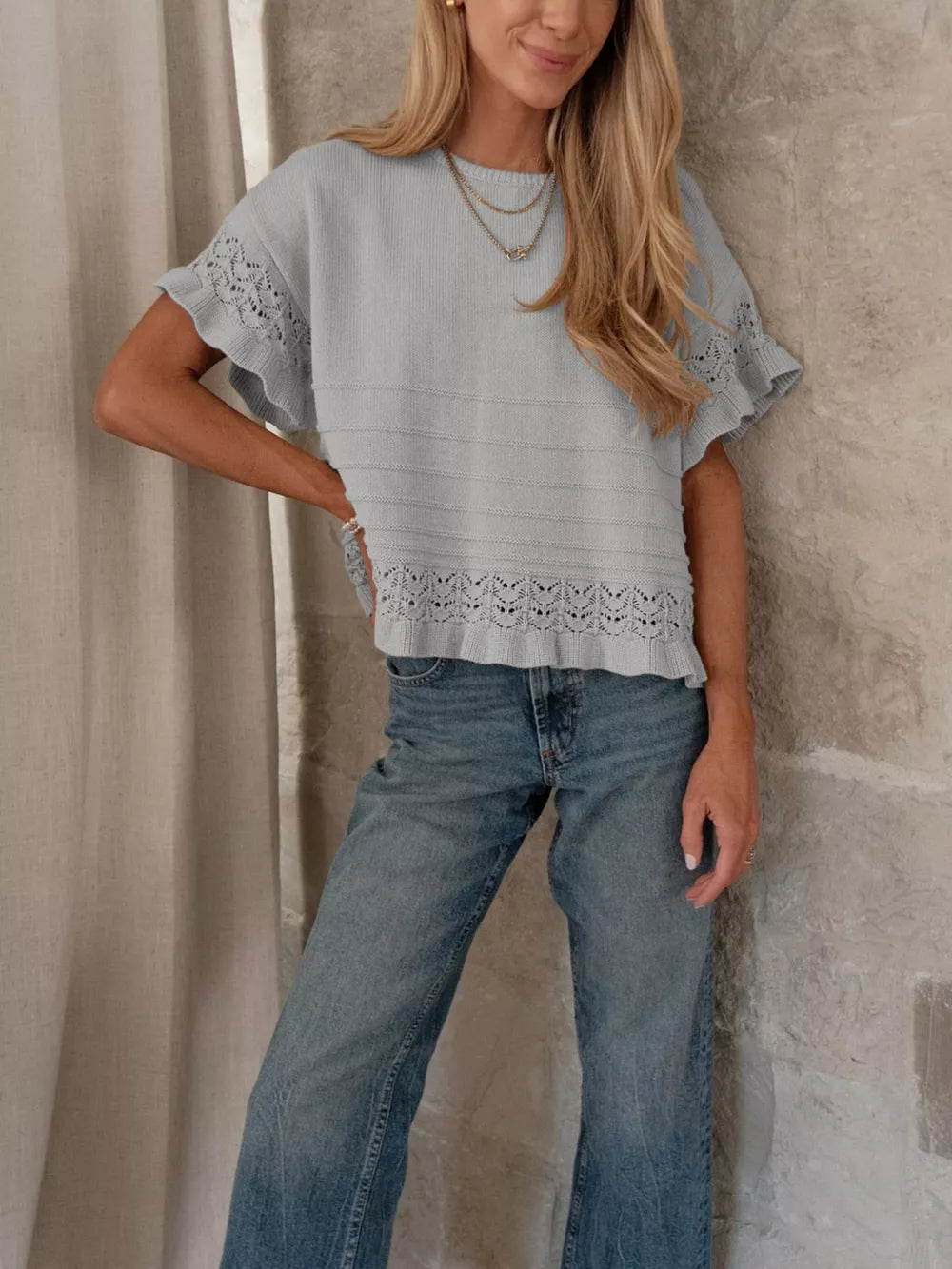 Light blue knit top with crew neck, short sleeves, and delicate lace trim.