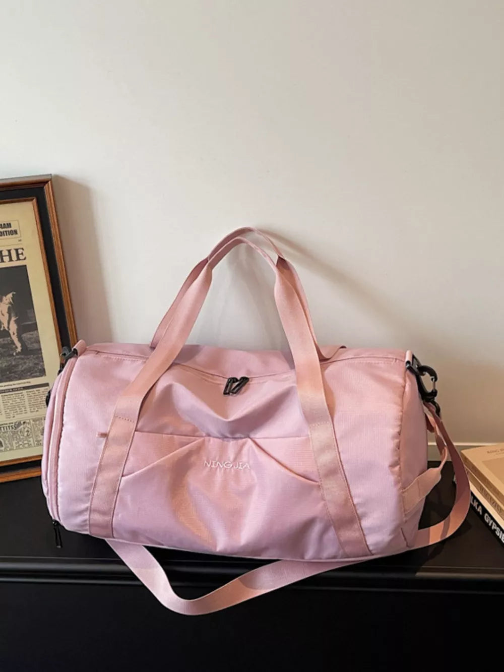 Pink nylon travel duffle bag with multiple pockets and adjustable strap.