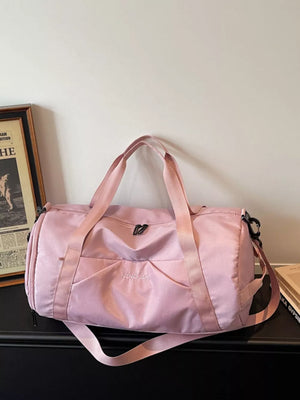 Pink nylon travel duffle bag with multiple pockets and adjustable strap.