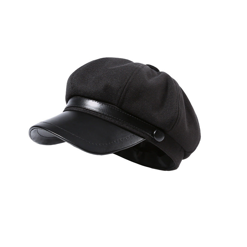 Black newsboy cap with faux-leather brim and button detail.