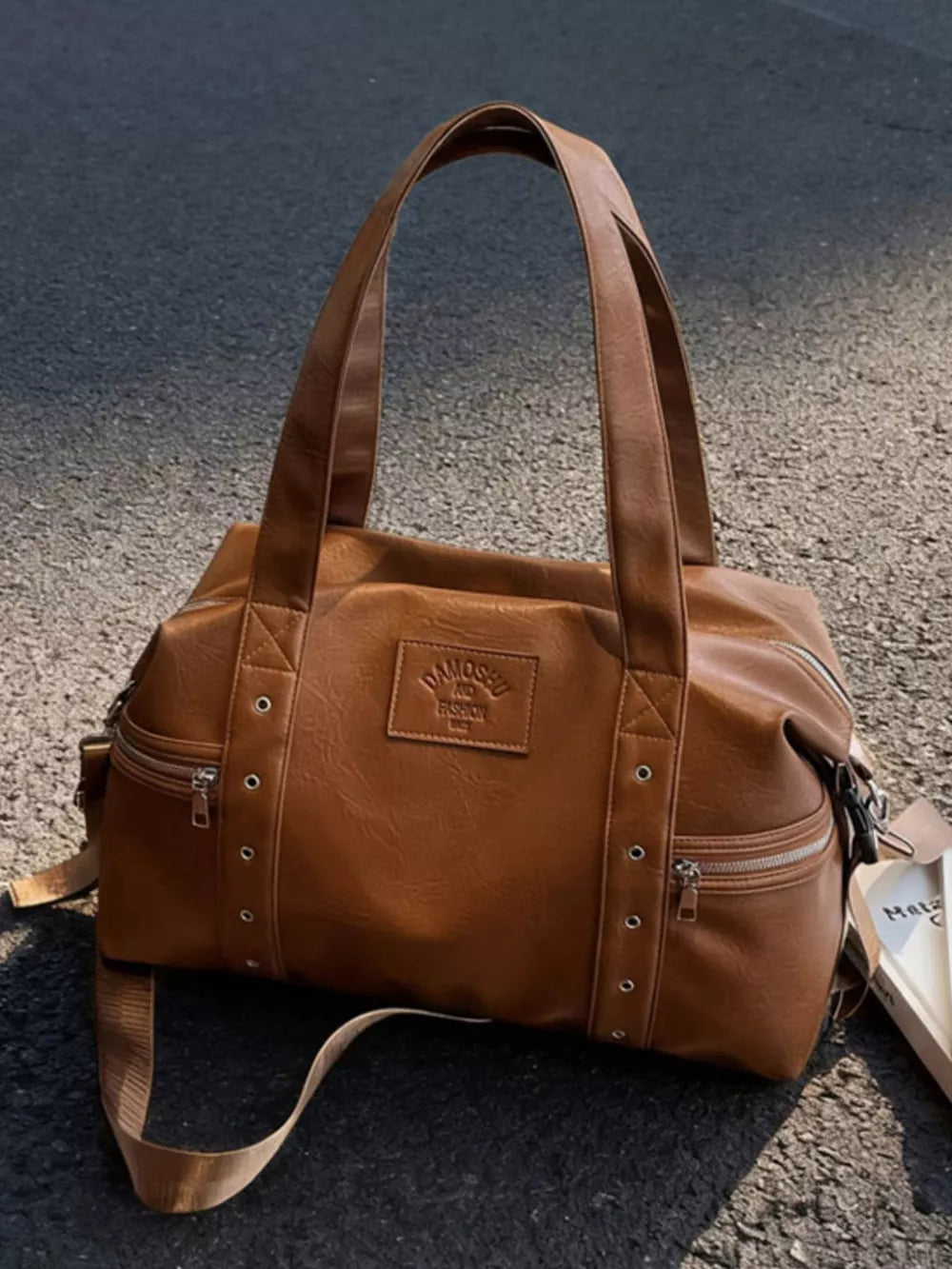 Chic brown pu leather shoulder bag with adjustable strap and zippered pockets.