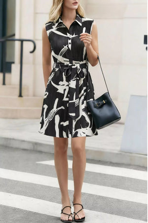 Chic abstract print a-line dress with belt, button front, and sleeveless design.