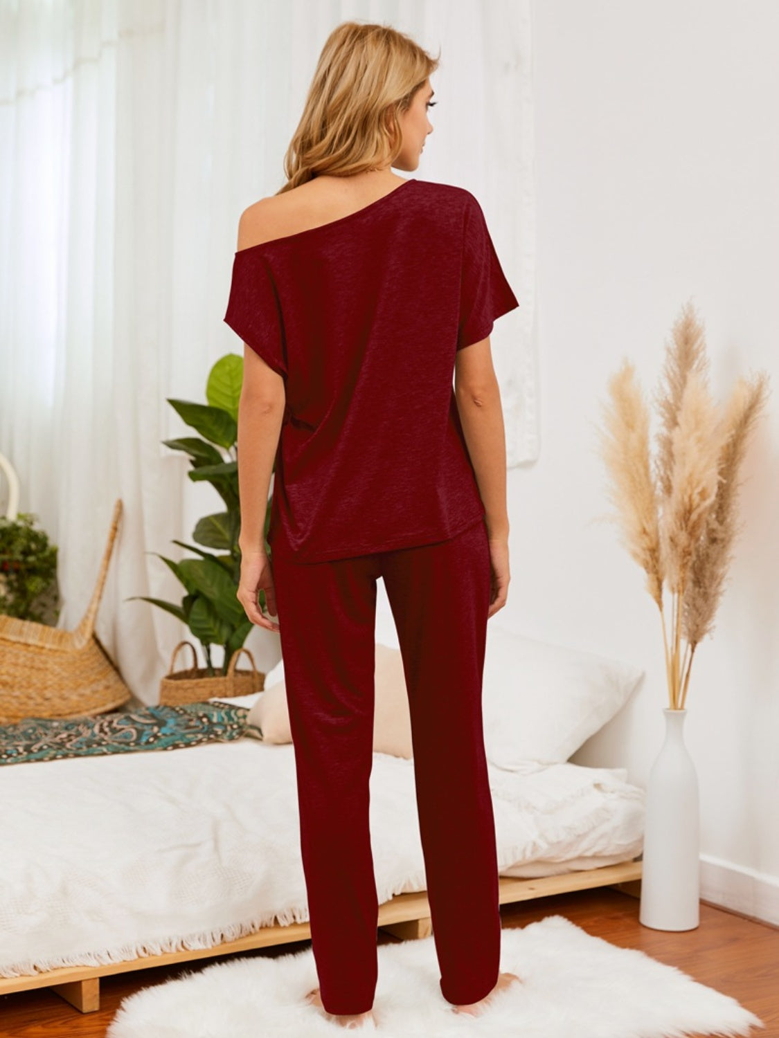 Burgundy loungewear set with asymmetric neckline and straight leg pants.