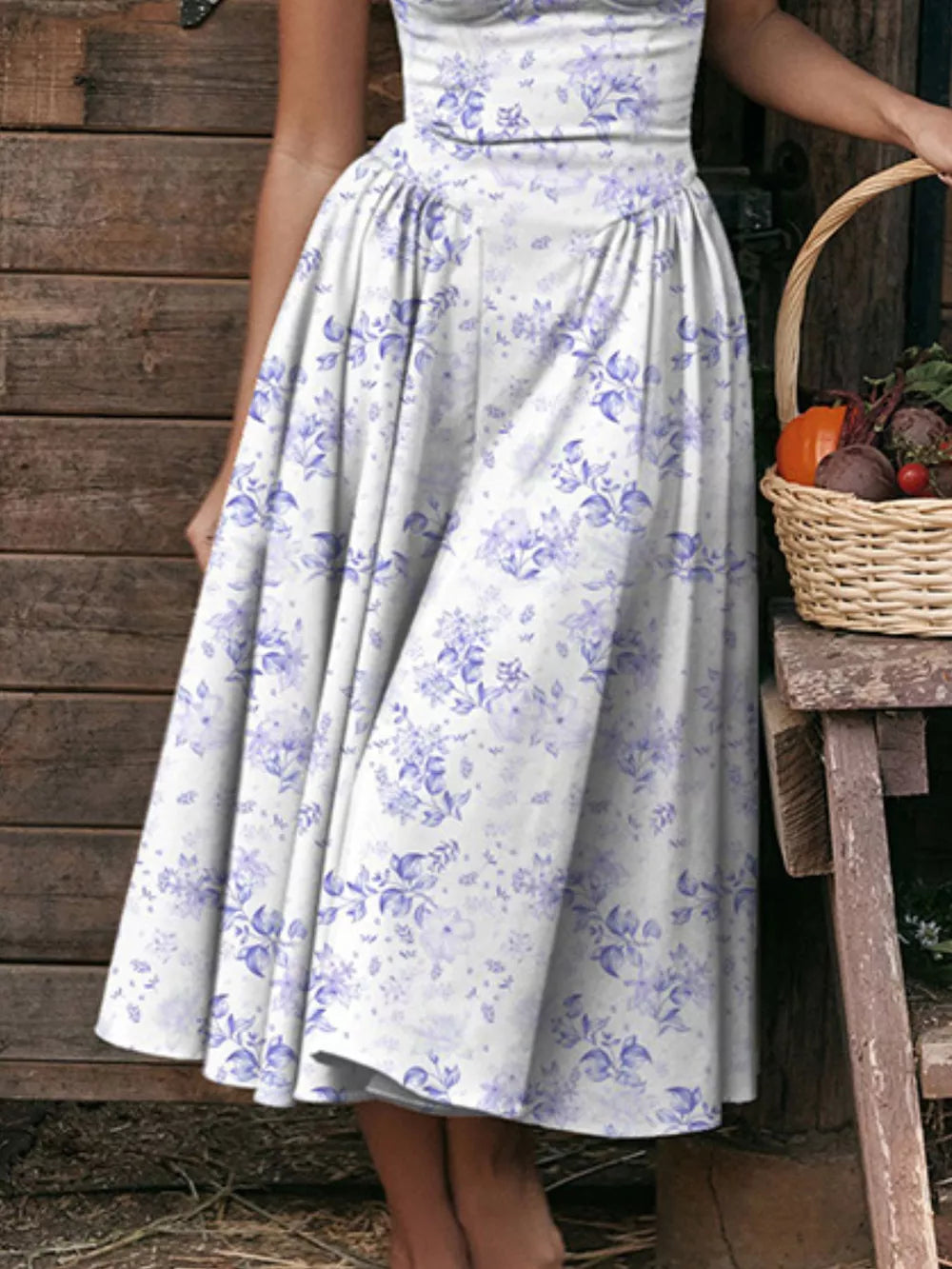 Floral midi dress with sweetheart neckline and spaghetti straps in white with blue floral print.