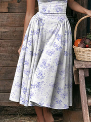 Floral midi dress with sweetheart neckline and spaghetti straps in white with blue floral print.