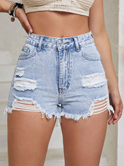 Light wash denim shorts with distressed ladder detailing and frayed hem.