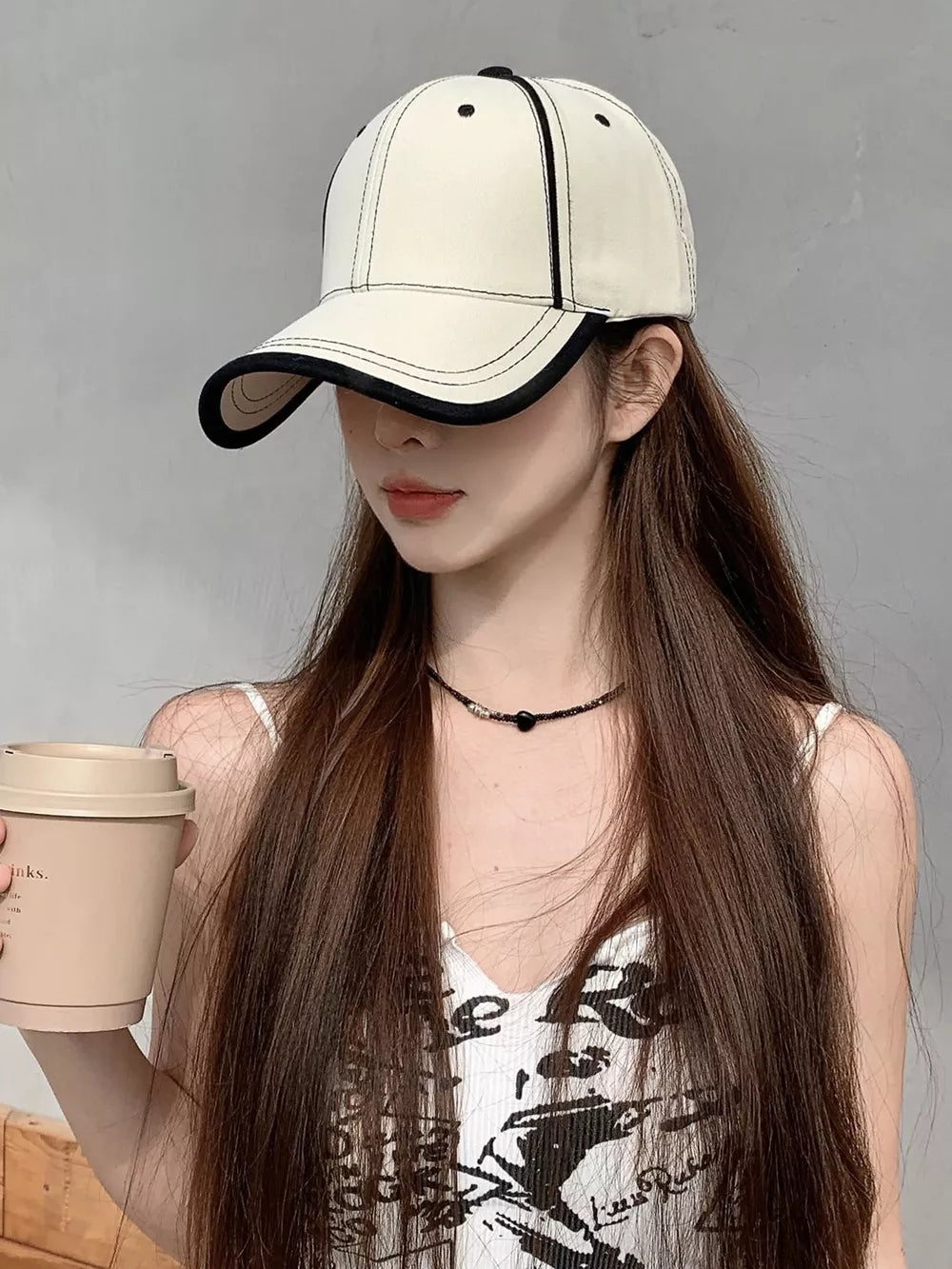 Cream white baseball cap with contrast stitching and black brim detail