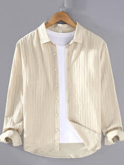 Textured long sleeve button-up shirt in apricot with classic collar, worn over a white t-shirt.