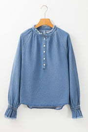 Light blue denim blouse with ruffled collar, button front, and ruffled cuffs.