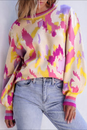 Abstract brushstroke knit sweater with puff sleeves and striped cuffs in floral colors.