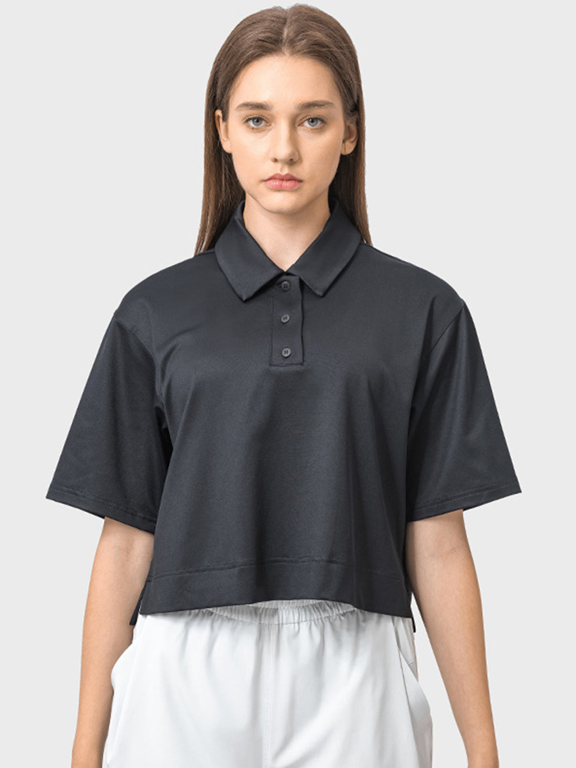 Black cropped polo sportif top with short sleeves and button placket.