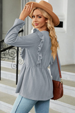 Light blue textured peplum blouse with ruffle detail and long sleeves.