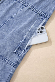 Acid wash denim shirtdress with raw hem detail and pocket holding a phone.
