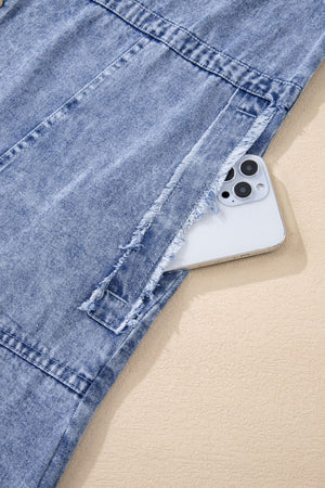 Acid wash denim shirtdress with raw hem detail and pocket holding a phone.