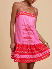 Playful pink mini dress with spaghetti straps and a red fish print, tiered hem