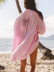 Pink button-down shirt dress with palm tree embroidery detail on back