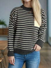 Asymmetrical stripe knit sweater in dark gray with cream pocket detail and crew neck.