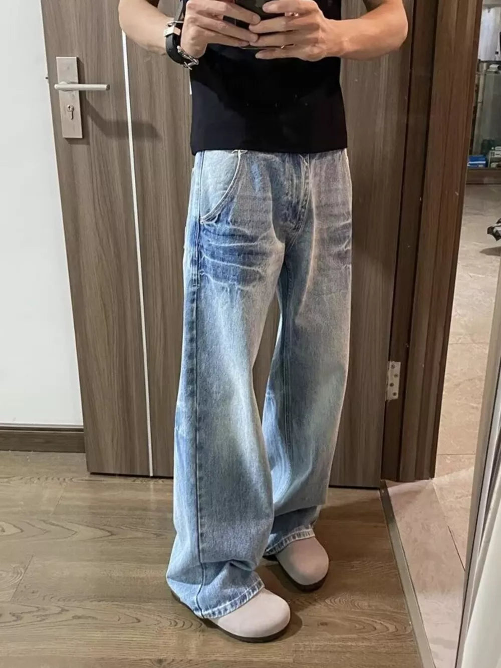 Men's vintage wash wide-leg jeans in light blue cotton, featuring a relaxed fit.