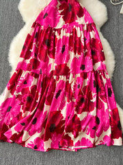 Vibrant floral tiered cami maternity swim dress with pink and red flowers on a cream background.