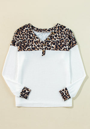 White waffle knit henley sweater with leopard print yoke and cuffs.
