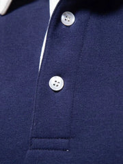 Navy long sleeve polo shirt with white collar trim and two button placket.
