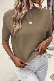 Off-the-shoulder ribbed knit top in olive with short dolman sleeves.