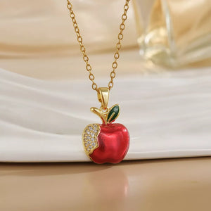 Gold-plated necklace with a red apple pendant, sparkling with crystals and a green leaf.
