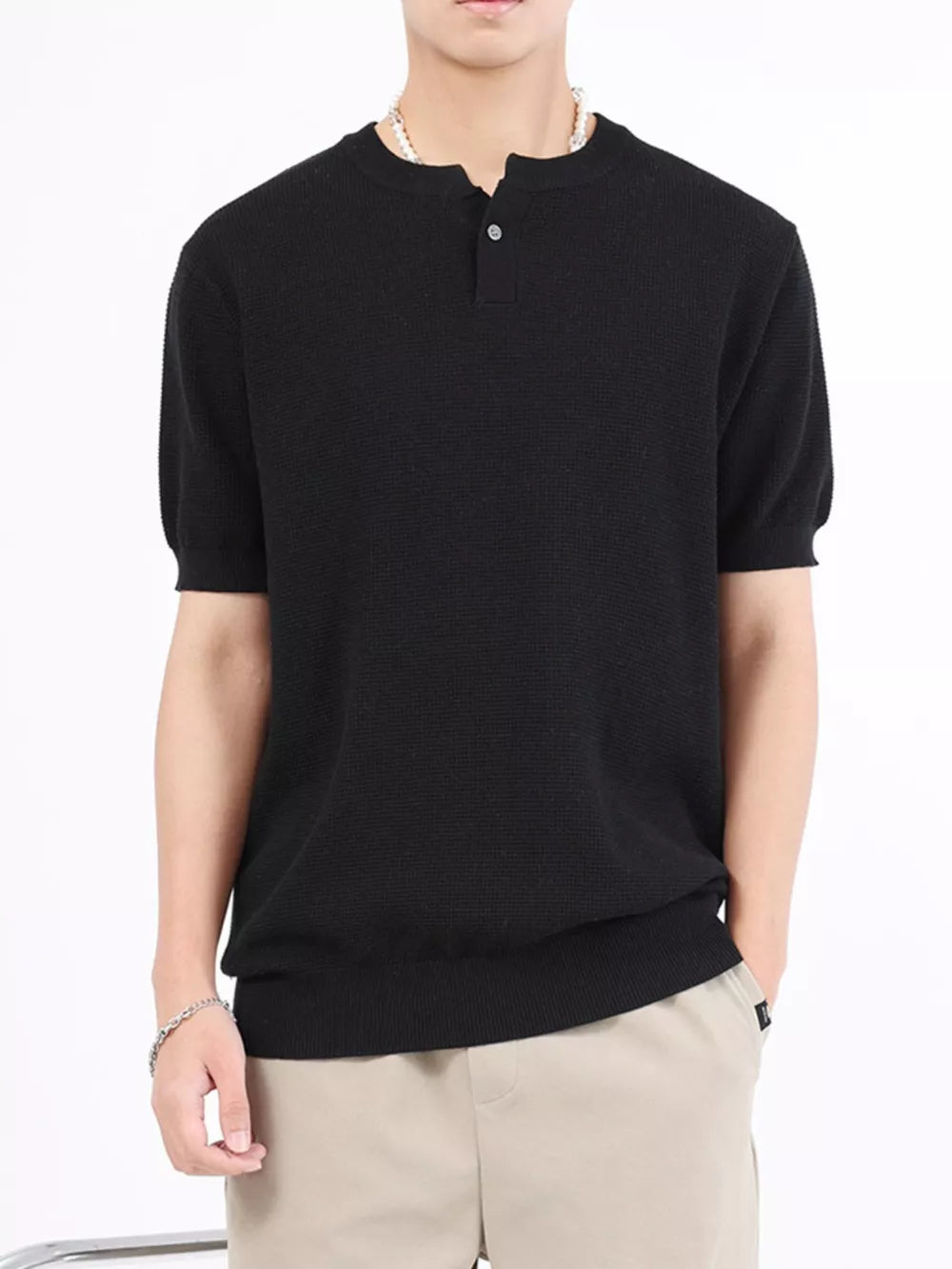 Men's black knitted henley with short sleeves and a two-button placket.