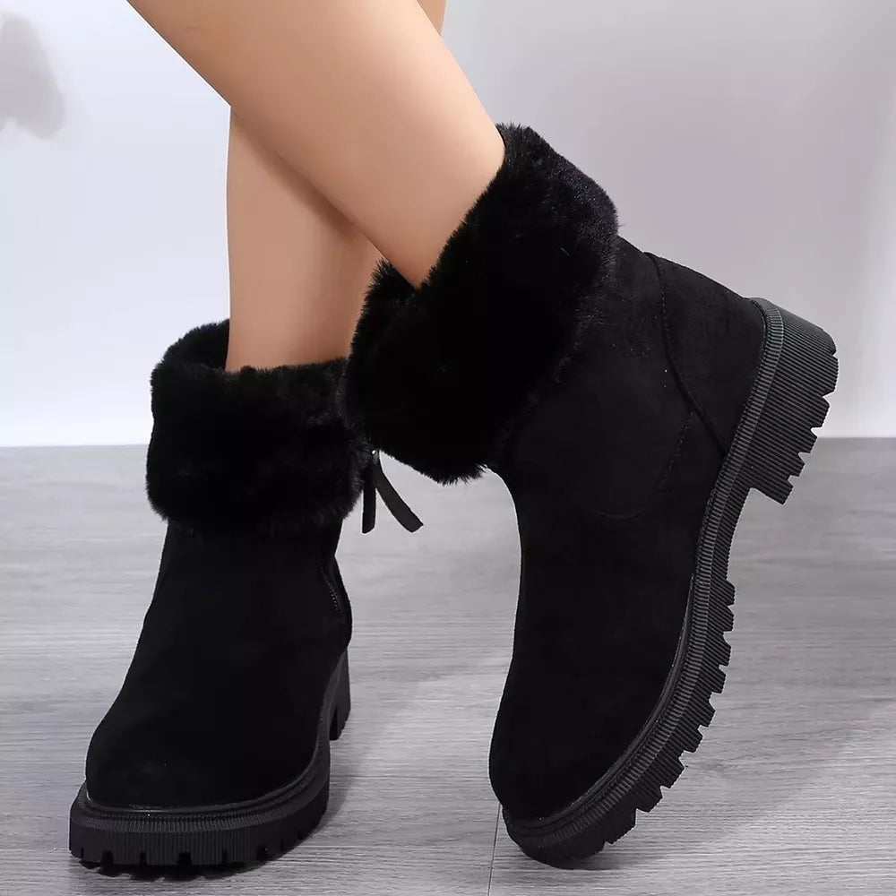 Black suede ankle boots with faux fur trim and side zipper detail on chunky sole.