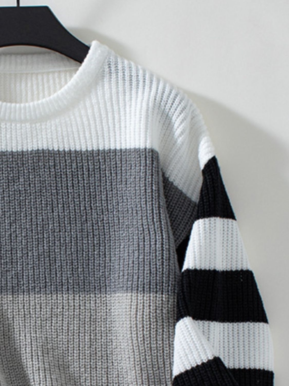 Colorblock stripe ribbed knit sweater with white, gray, and black horizontal stripes.